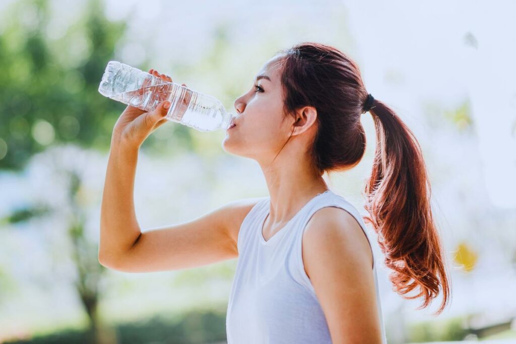 mulher tomando agua para se refrescar